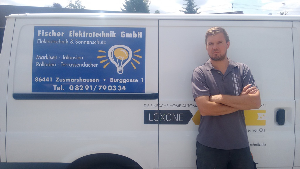 Team der Fischer Elektrotechnik vor dem Firmenfahrzeug